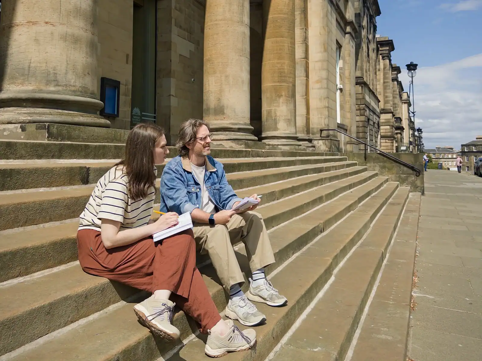 Seed & Solace team reviewing notes on the stone steps of an Edinburgh building