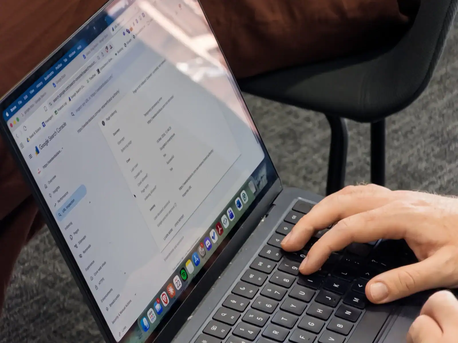 Hands typing on a laptop while working on a website's SEO